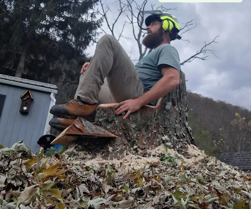 Jason Tubbs sitting on a large stump